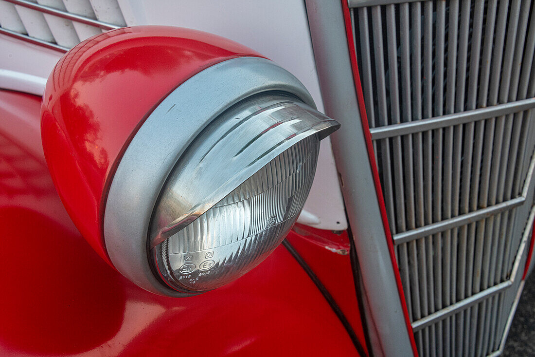 Detail des Scheinwerfers und des Kühlergrills an einem roten klassischen amerikanischen Ford in Habana, Havanna, Kuba.