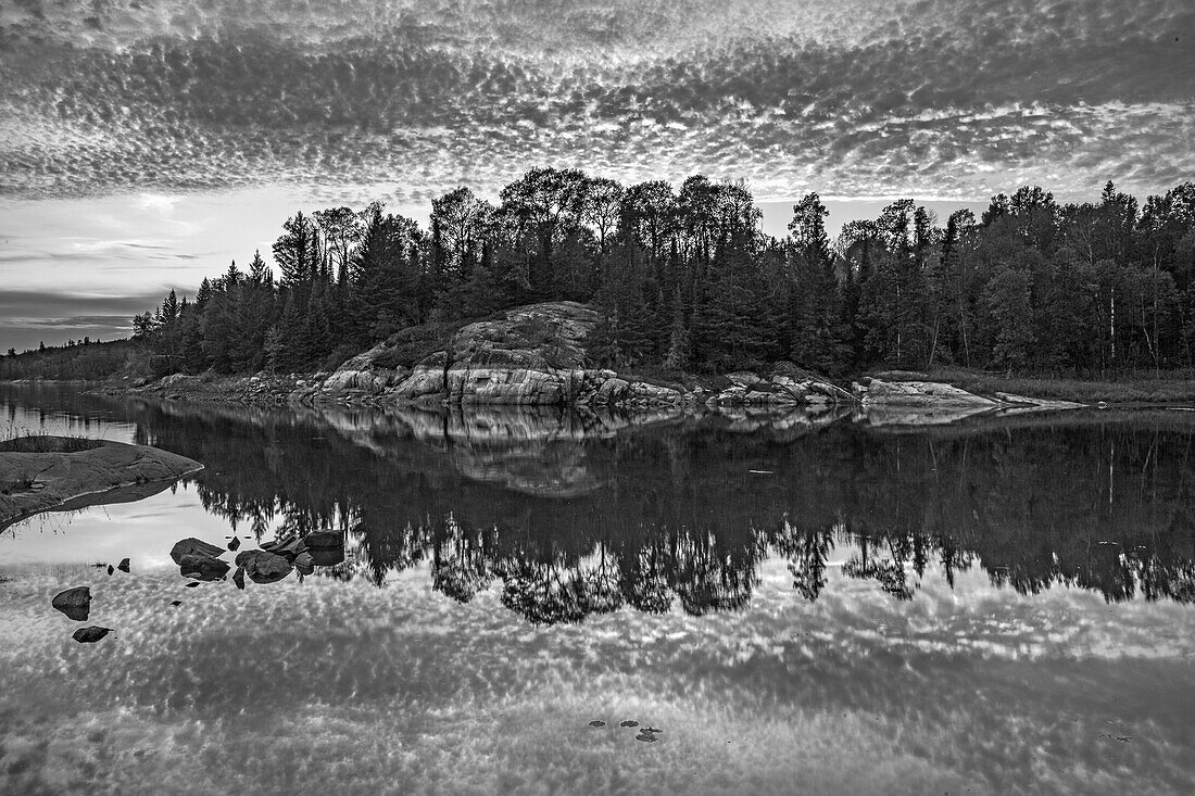 Kanada, Ontario, Bezirk Kenora. Schwarz-Weiß-Wolken spiegeln sich im Middle Lake