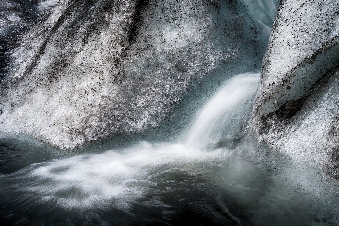 Iceland, abstract ice, ash and meltwater flume on the Solheimajokull Glacier.