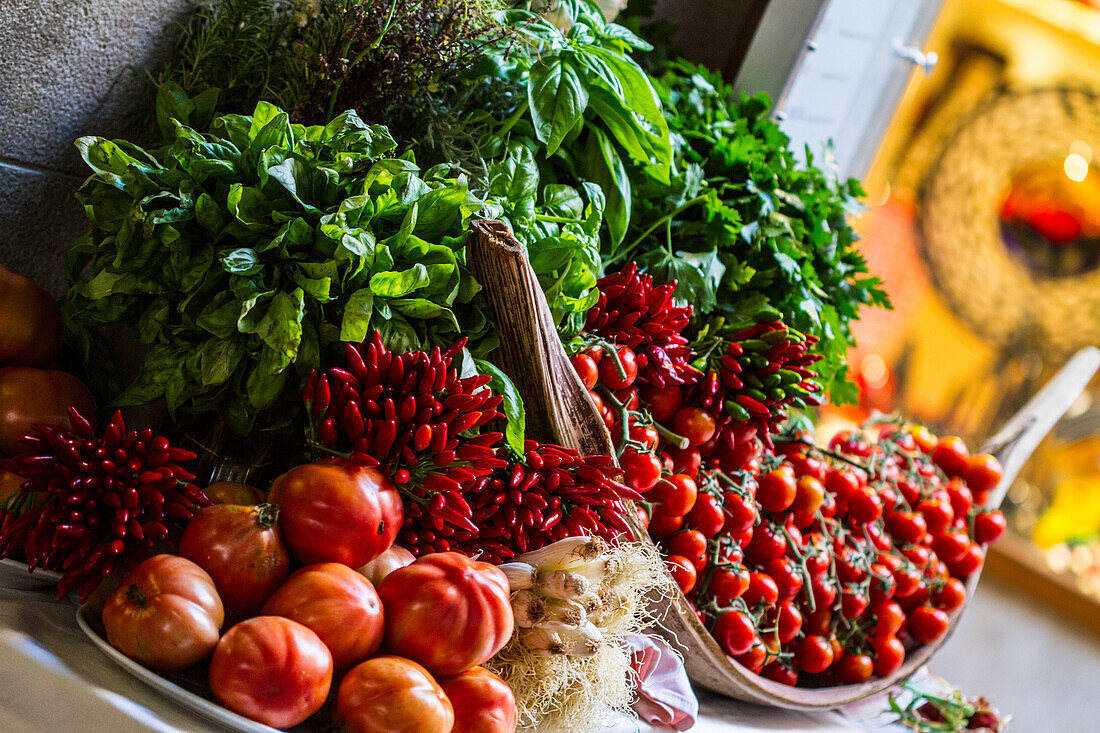 Venice, Italy. Bundle of Fresh Herbs, red Picante Peppers, onions, and tomatoes