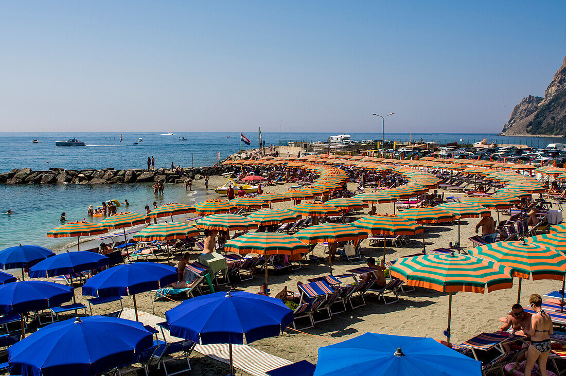 Beach umbrellas lining the beach in Monterosso al Mare, Cinque Terre, Italy.