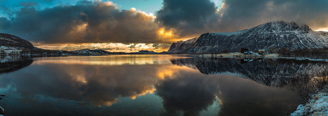 Europe, Norway. Snow covered mountains surround the still waters near Leknes on Vestvagoy, a part of the Lofoten Islands in Nordland.