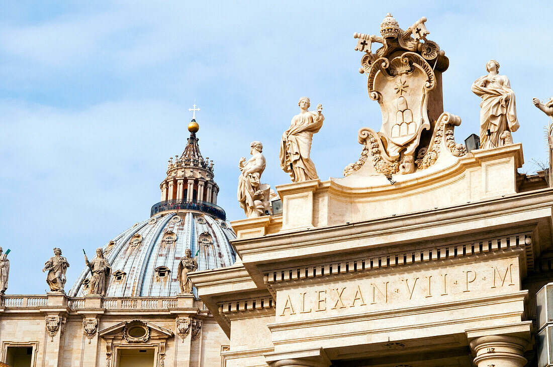 Papstinsignien zwischen zwei Heiligenstatuen auf Berninis Säulengang aus dem 17. Jahrhundert, Piazza San Pietro, Petersplatz, Vatikanstadt, Unesco-Weltkulturerbe, Rom, Latium, Italien