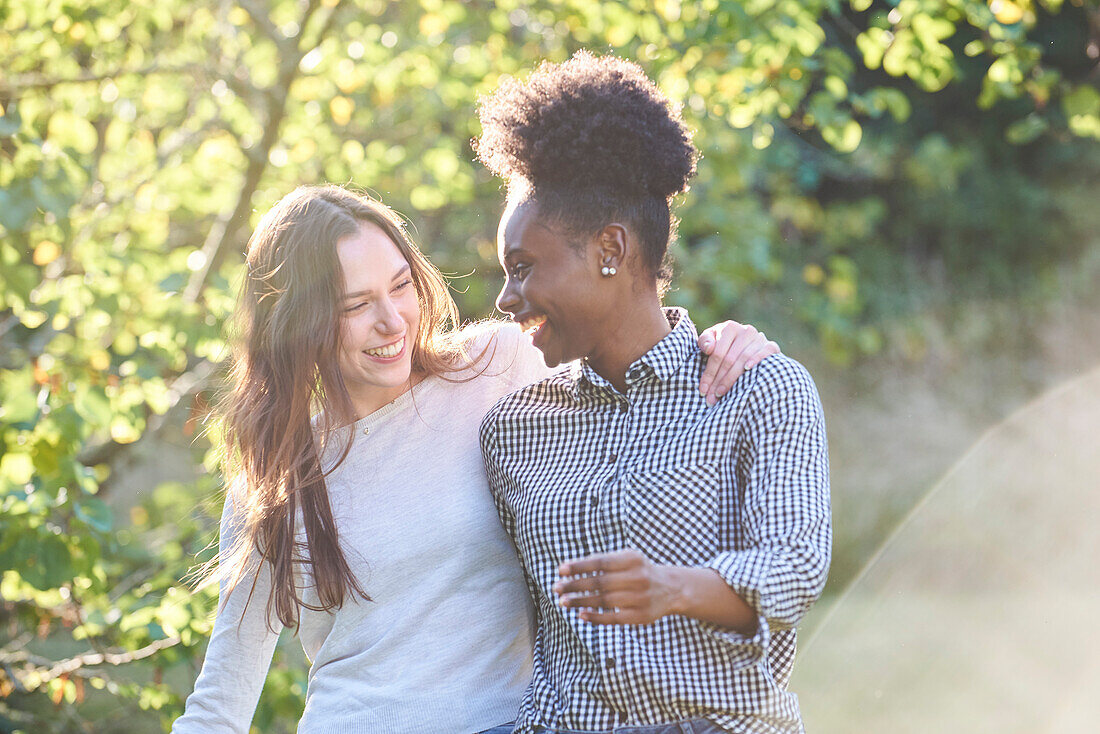 Smiling young friends walking in public park