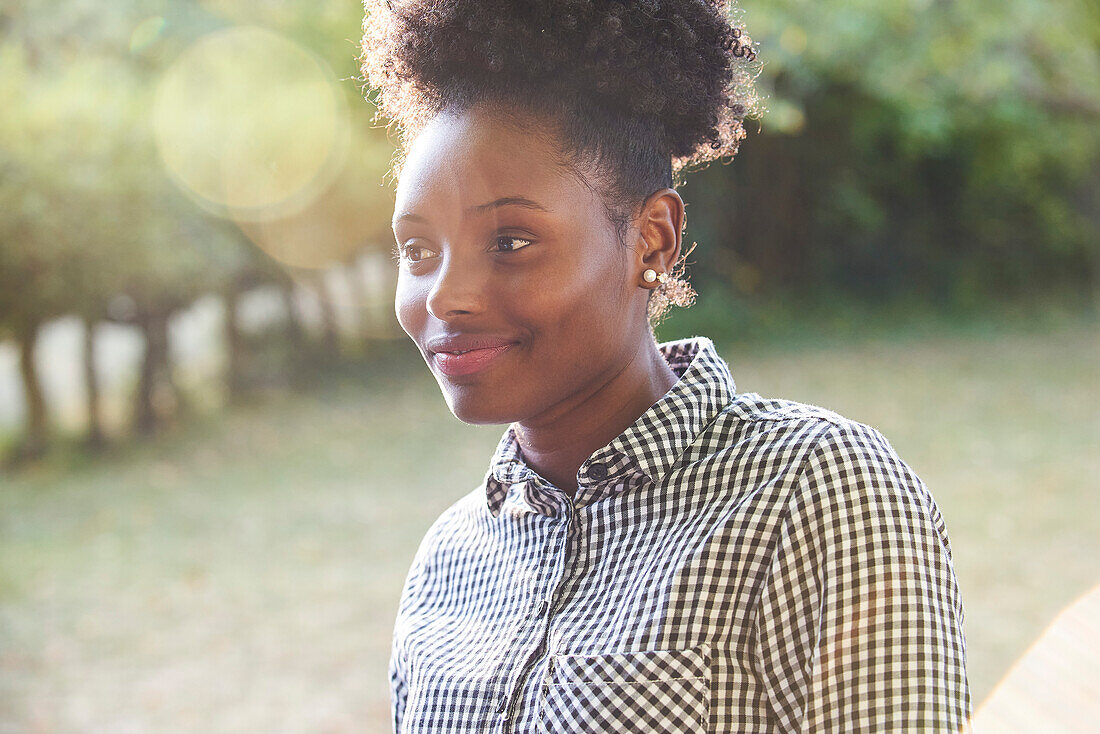 Smiling young woman sitting in park