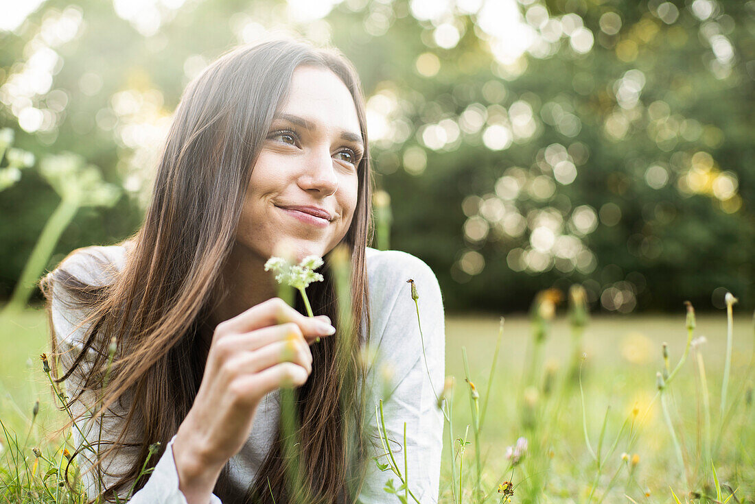 Portrait of smiling young woman lying in park