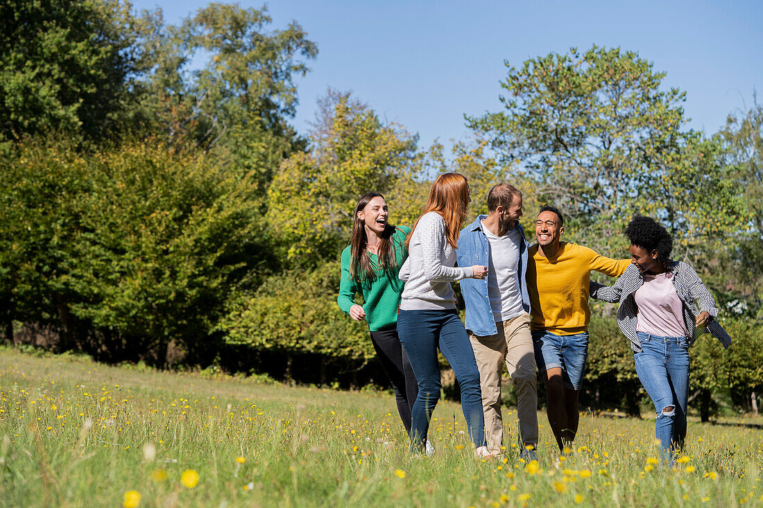 Happy young friends having fun while walking together in park