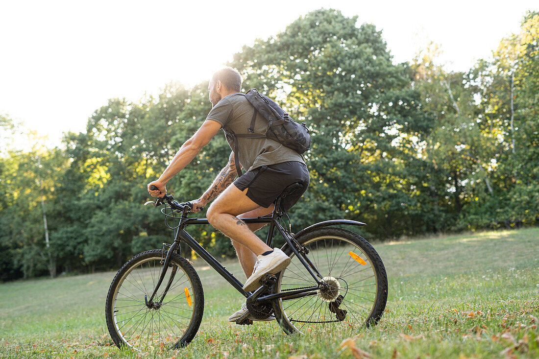 Young man riding a bicycle in forest