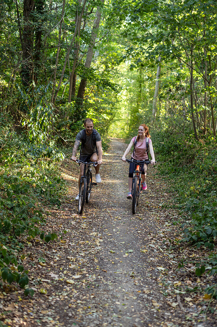 Young couple cycling in forest