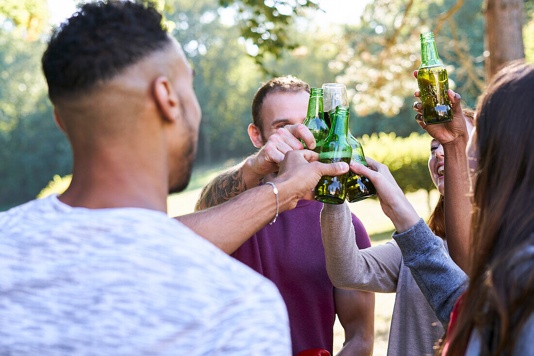 Junge Freunde trinken Bier, während sie im Park stehen