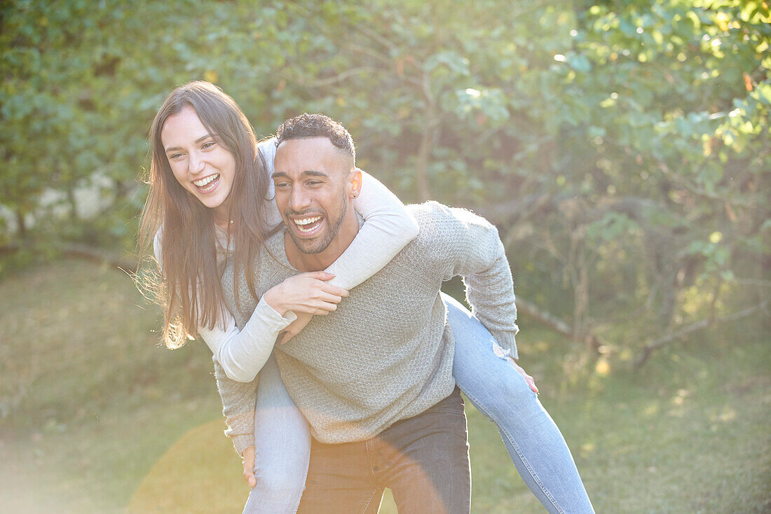 Smiling young man giving piggyback ride to his partner