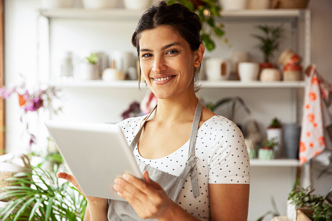 Young adult female nursery worker looking and smiling at the camera