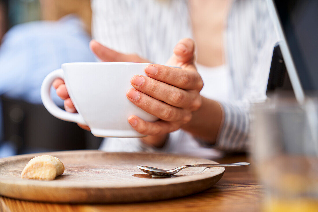 Nahaufnahme von Frauenhänden, die eine Tasse Kaffee halten