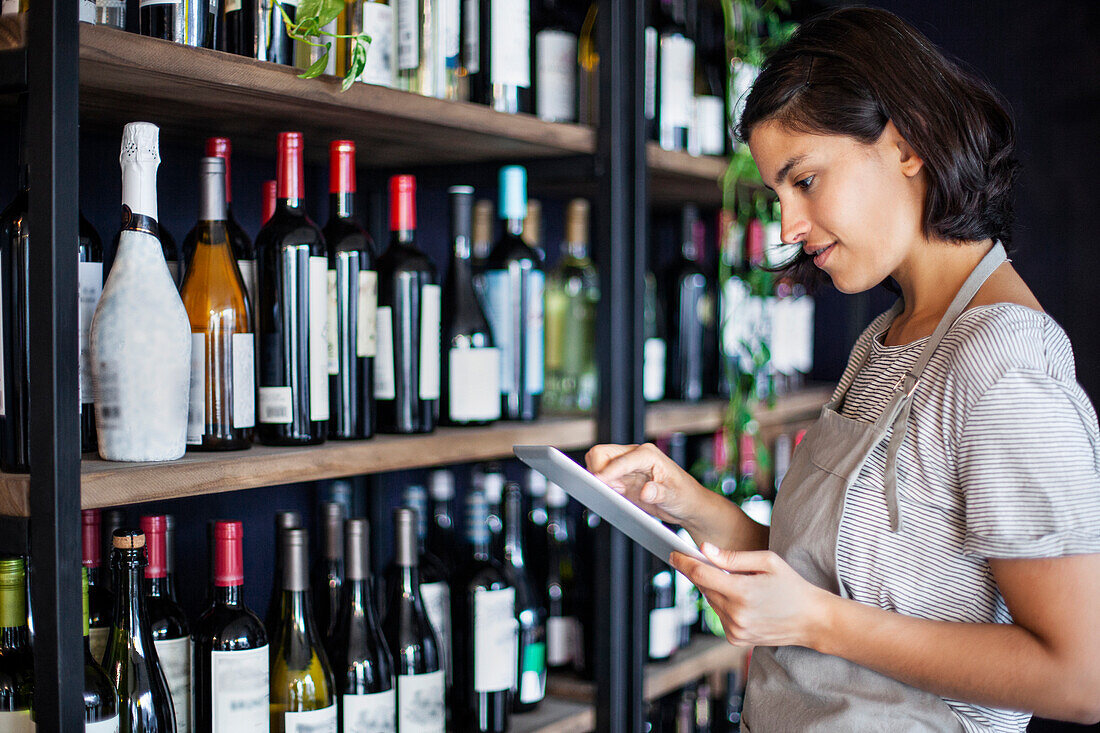 Wine shop owner setting up online store on digital tablet