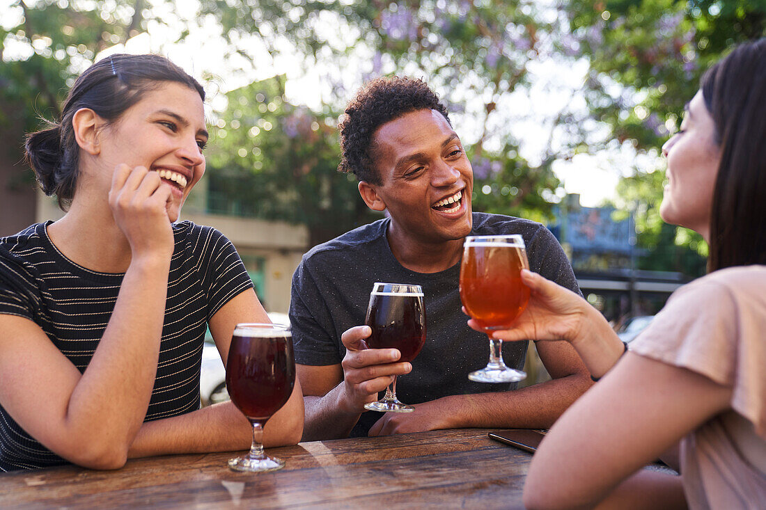 Eine Gruppe fröhlicher Freunde trinkt bei der Happy Hour Craft-Bier