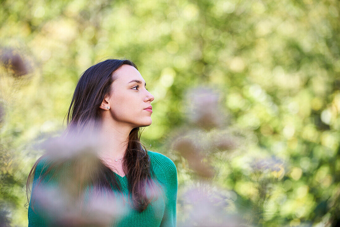 Thoughtful young woman standing in public park