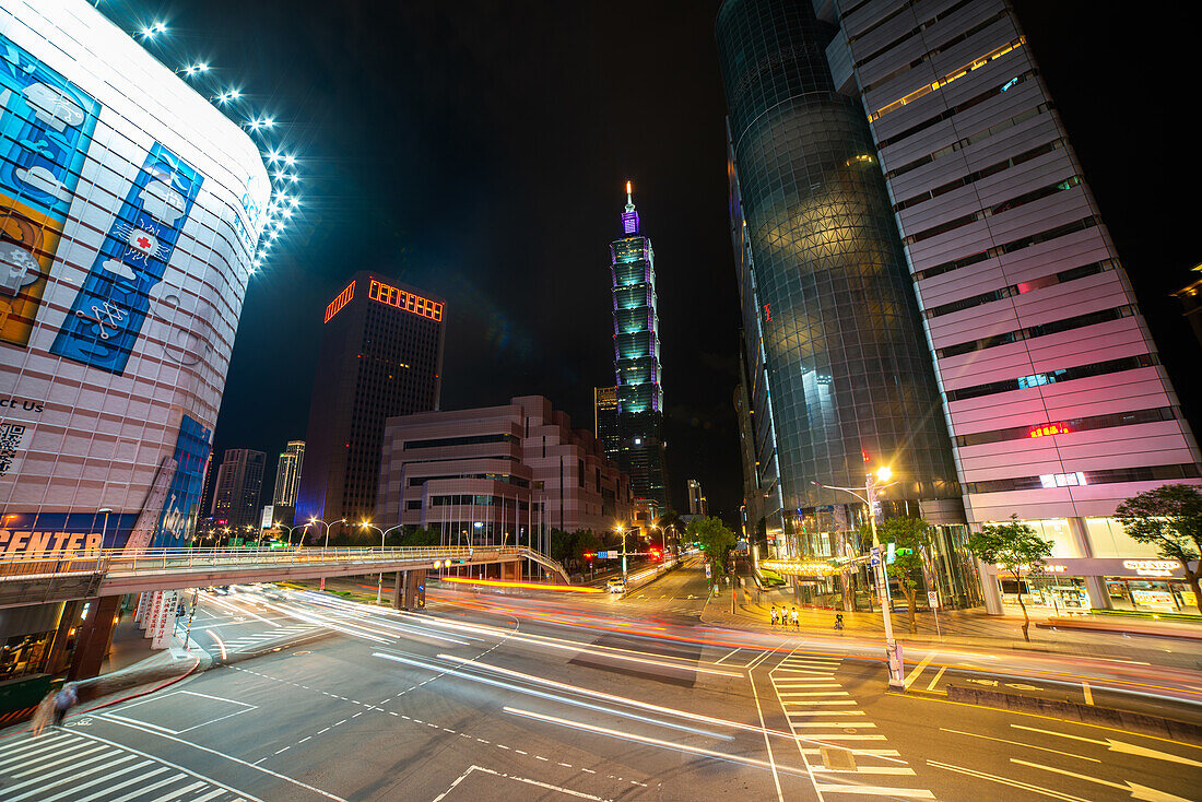Traffic moving on city street with Taipei 101 building in background, Taiwan