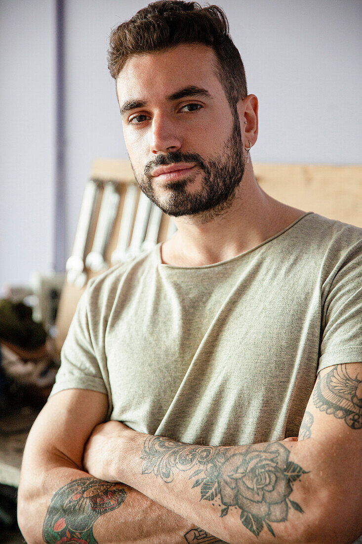 Young adult male mechanic standing in workshop