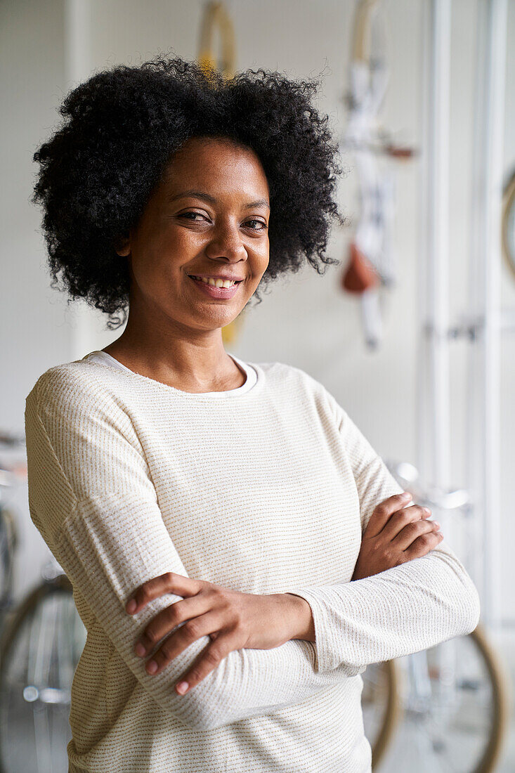 Mittlere Einstellung einer afroamerikanischen Unternehmerin, die in die Kamera schaut, während sie in ihrem Geschäft steht