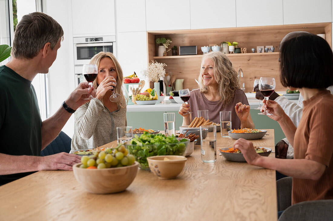 Diverse group of middle-aged friends having together at home