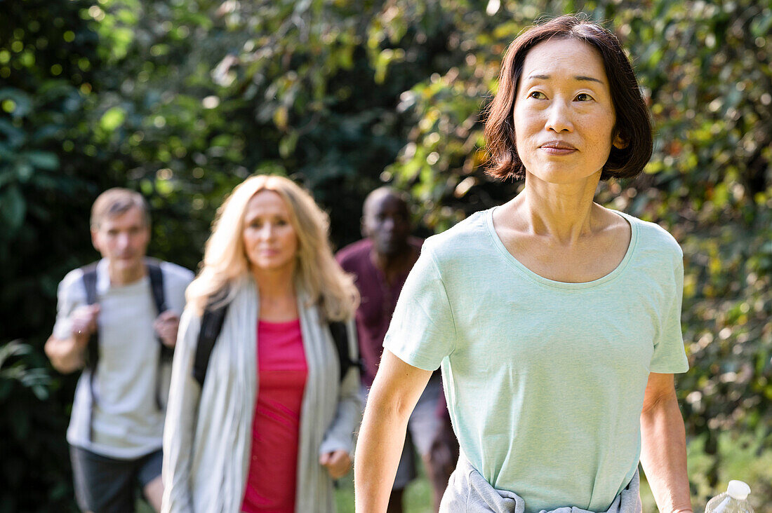 Gruppe von verschiedenen älteren Freunden beim Wandern im Wald