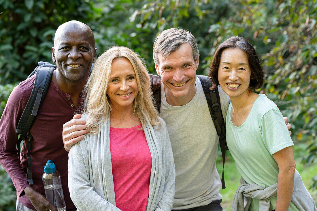 Two diverse senior couples enjoying a walk out in the woods