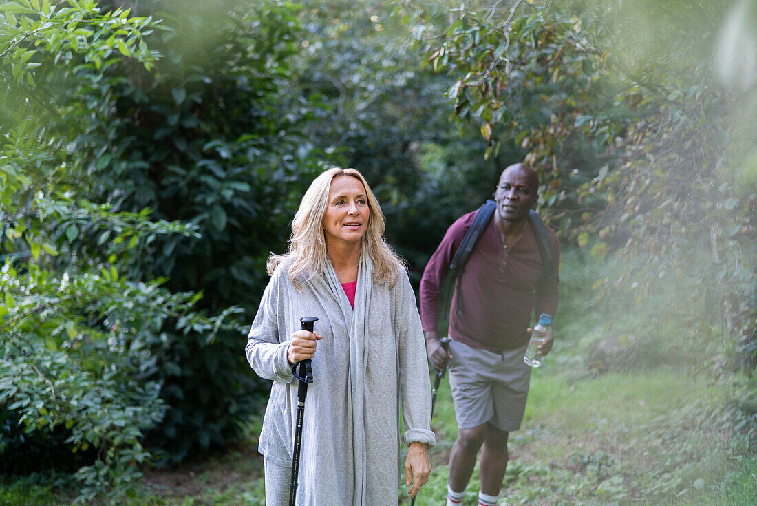 Senior couple doing hiking tour in the woods during daytime