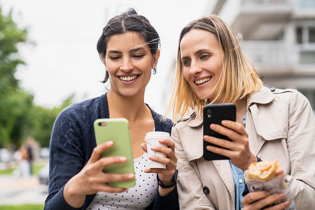 Mid-shot of two female freelance digital nomads looking at their online postings