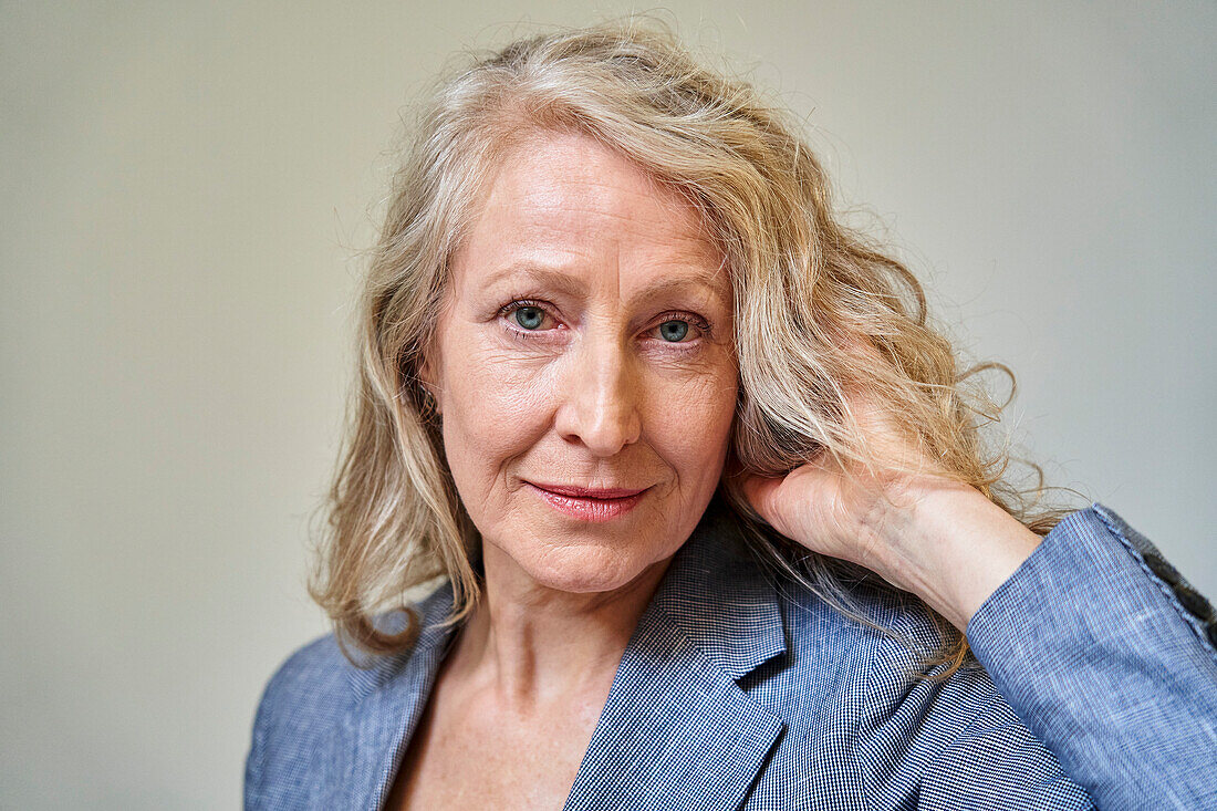 Senior blonde woman looking at the camera while holding her hair