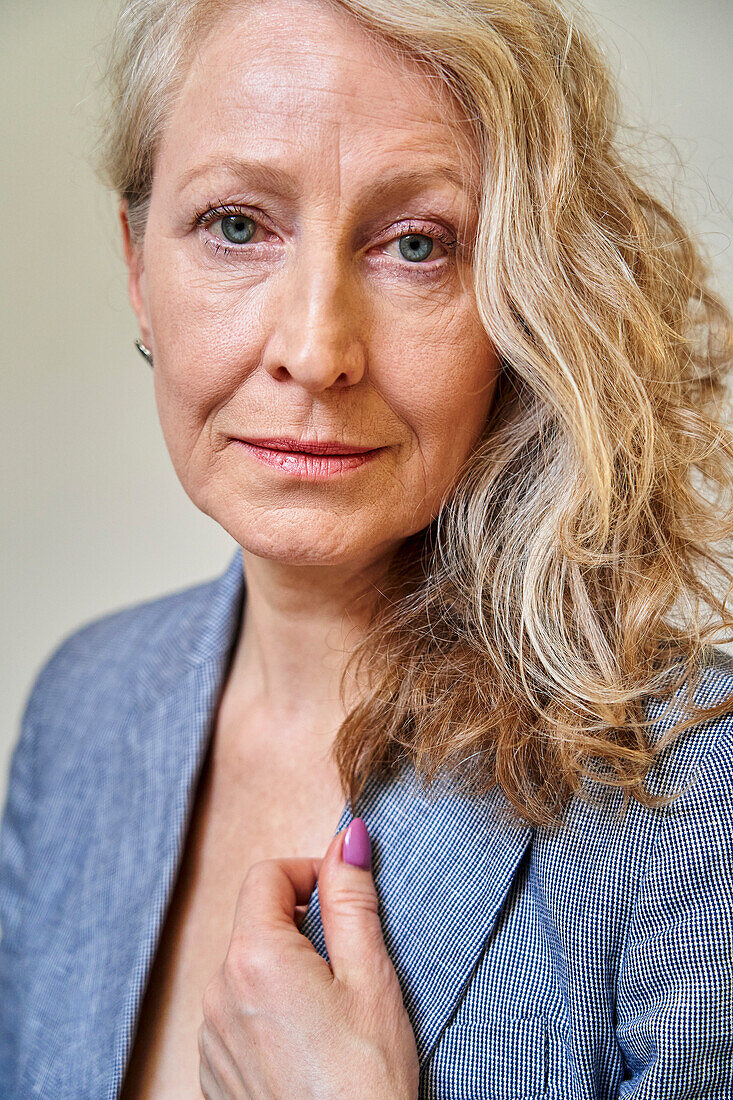 Beautiful senior blonde woman looking at the camera against white background