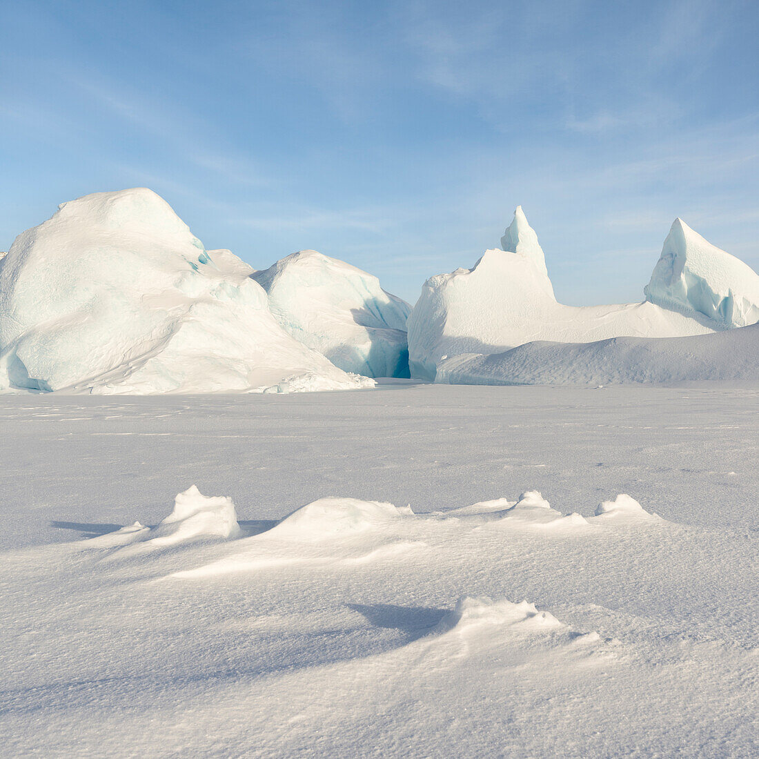 Im Meereis der Melville-Bucht, in der Nähe von Kullorsuaq im hohen Norden Westgrönlands, eingefrorener Eisberg.