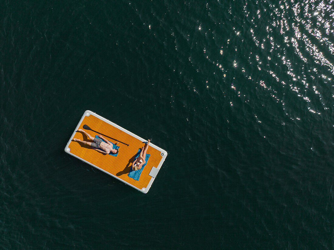 People relaxing on paddleboard