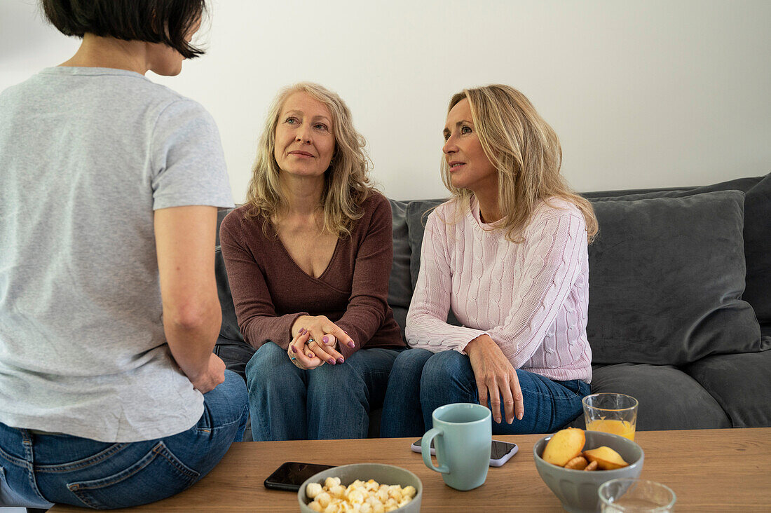 Drei attraktive ältere Damen unterhalten sich zu Hause