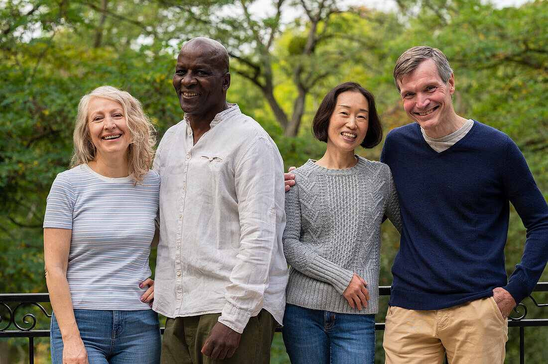 Middle-aged diverse couples hanging out in public park