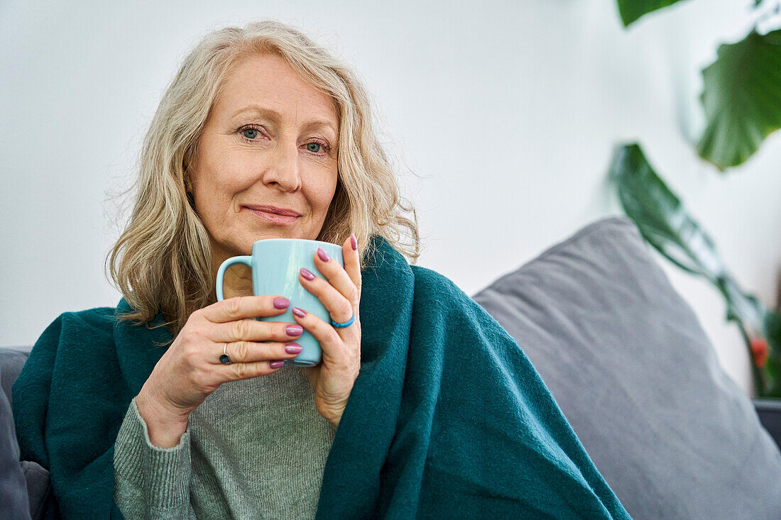Senior woman having cup of tea while looking at the camera