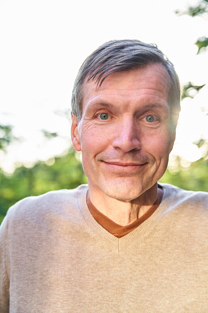 Smiling senior man looking at the camera while standing outdoors