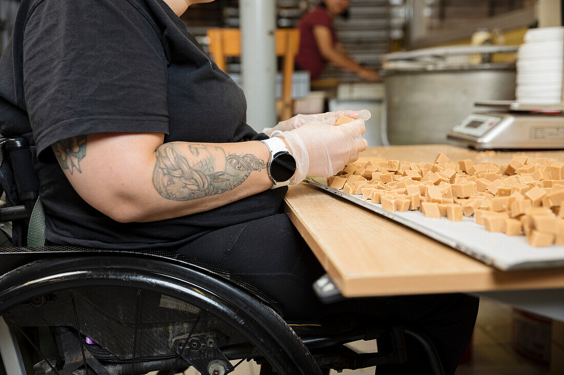 Behinderte Frau bei der Arbeit in einer Lebensmittelfabrik