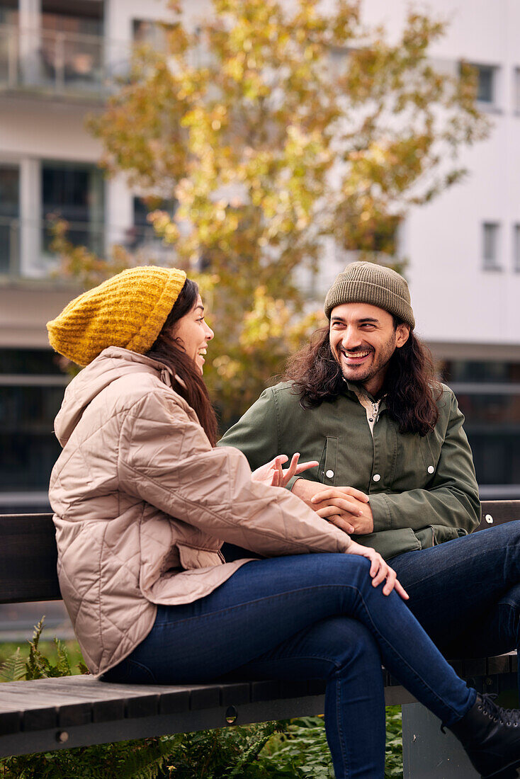 Man and woman talking on bench