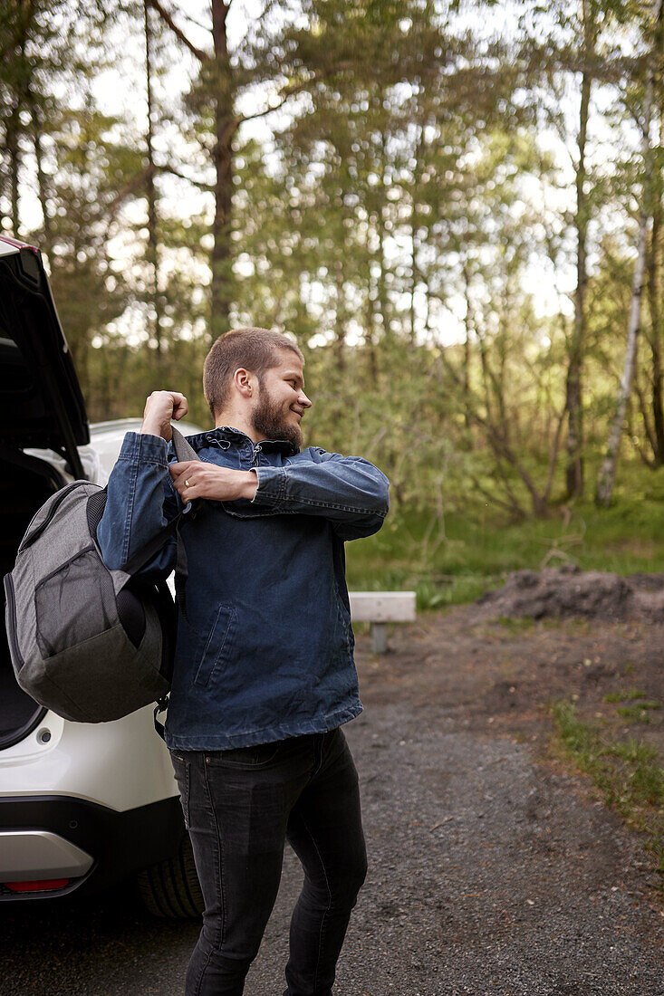 Mann setzt Rucksack auf