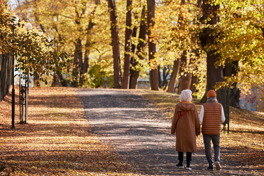 Älteres Paar beim Spaziergang im herbstlichen Park