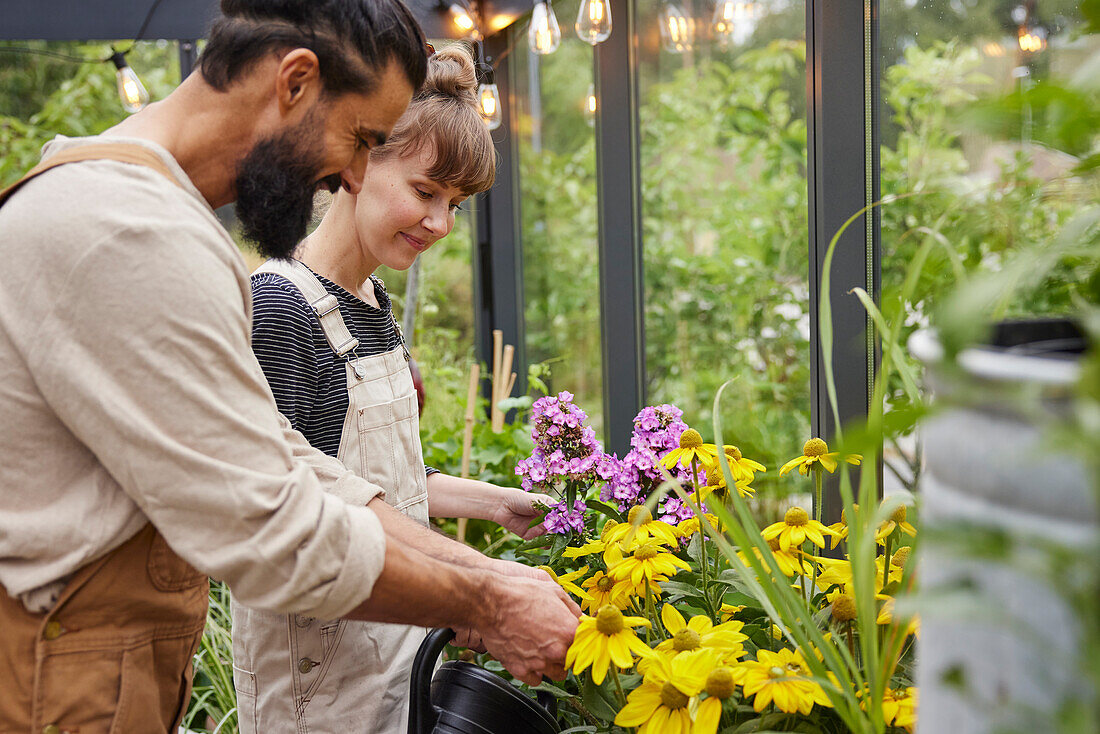 Paar bei der Gartenarbeit im Gewächshaus