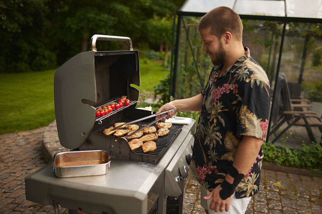 Mann bereitet Essen auf dem Grill zu