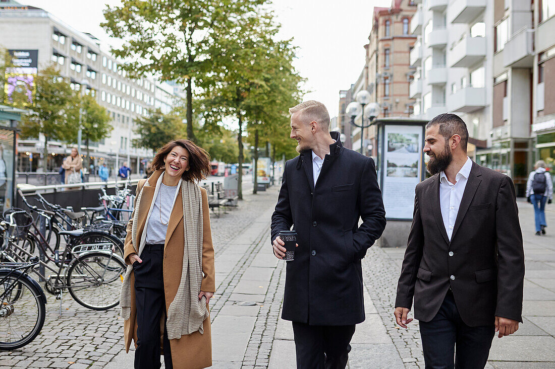 Smiling colleagues walking in street
