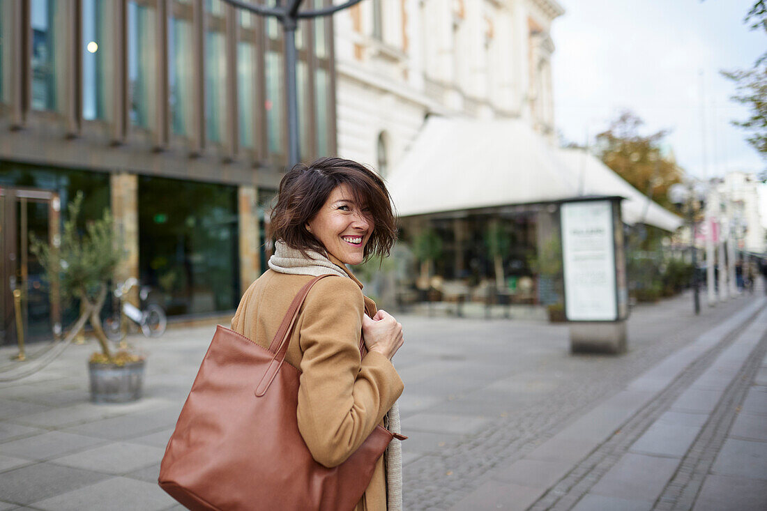 Portrait of smiling woman walking in street