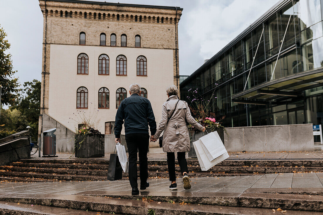 Paar geht in der Stadt mit Einkaufstaschen spazieren