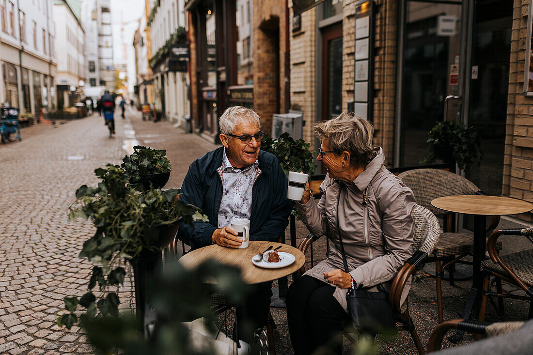 Senior couple drinking coffee in sidewalk cafe