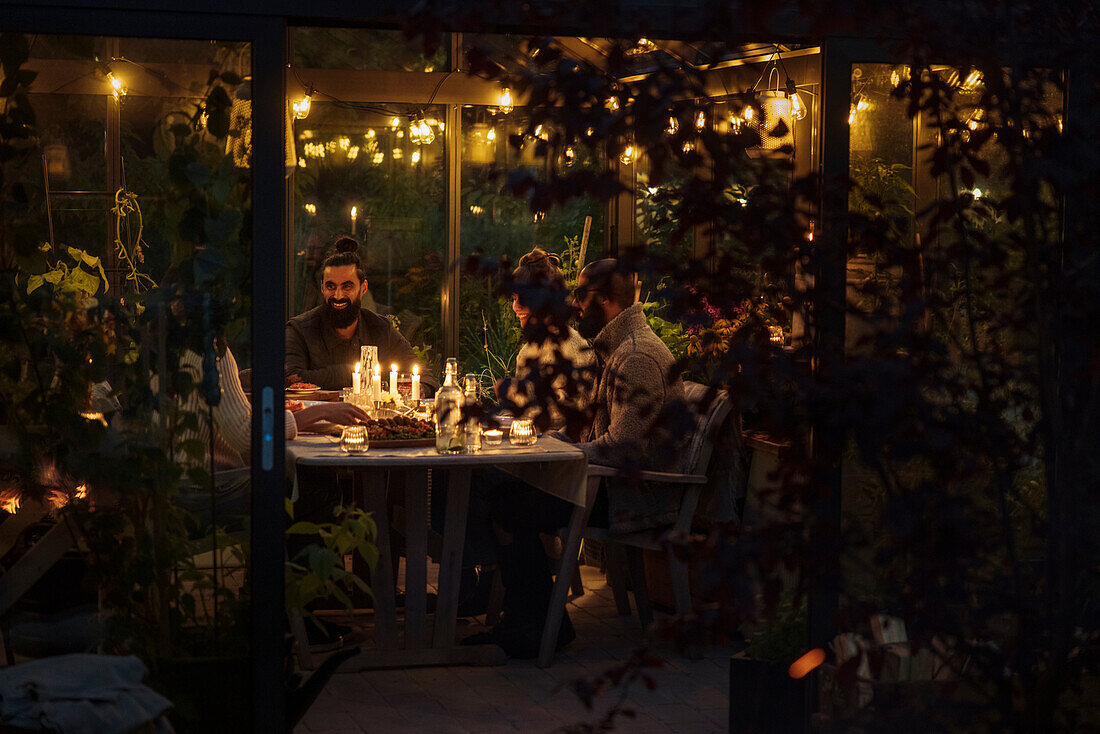 Friends having meal in greenhouse