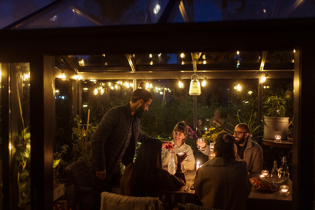 Friends having meal in greenhouse