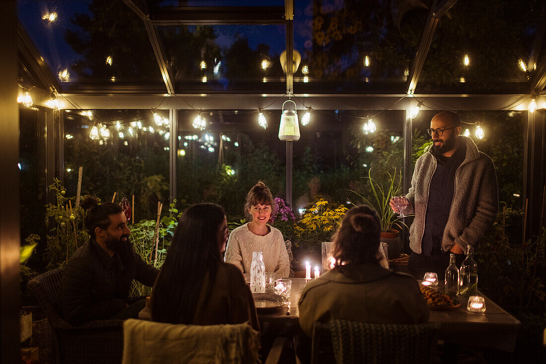 Friends having meal in greenhouse