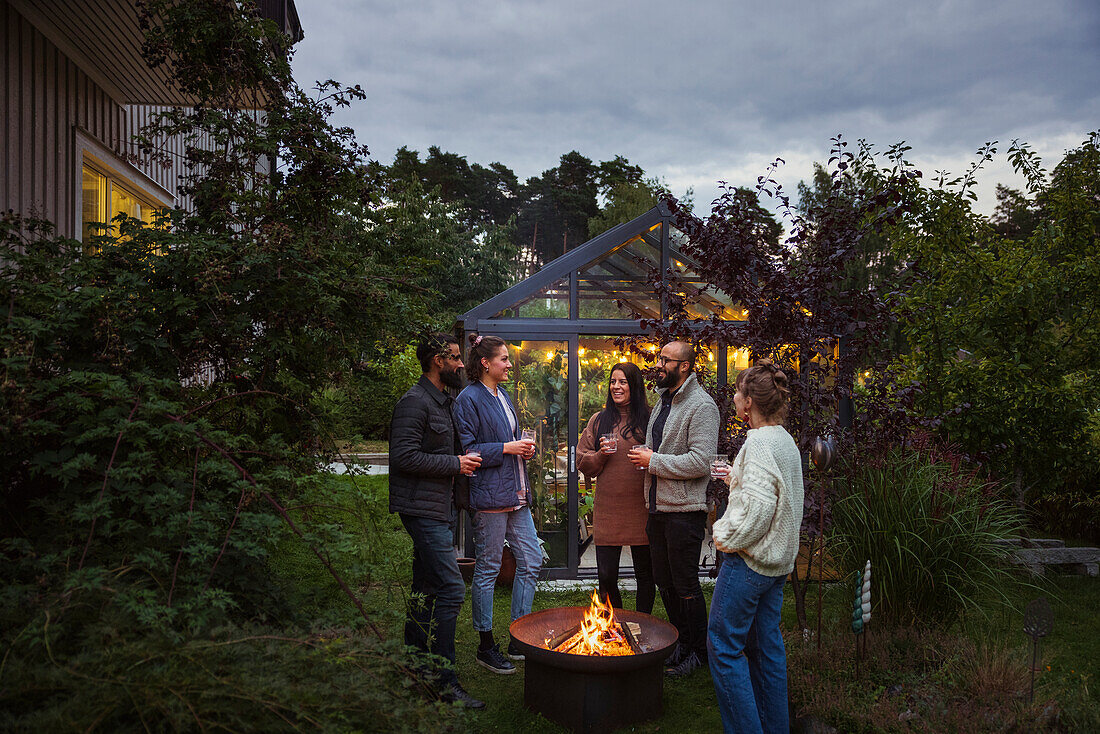 Glückliche Freunde unterhalten sich im Garten